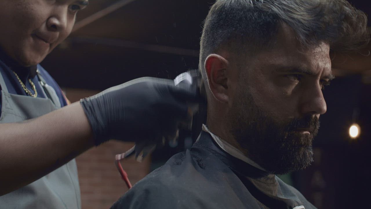 Barbeiro finalizando um corte com navalha